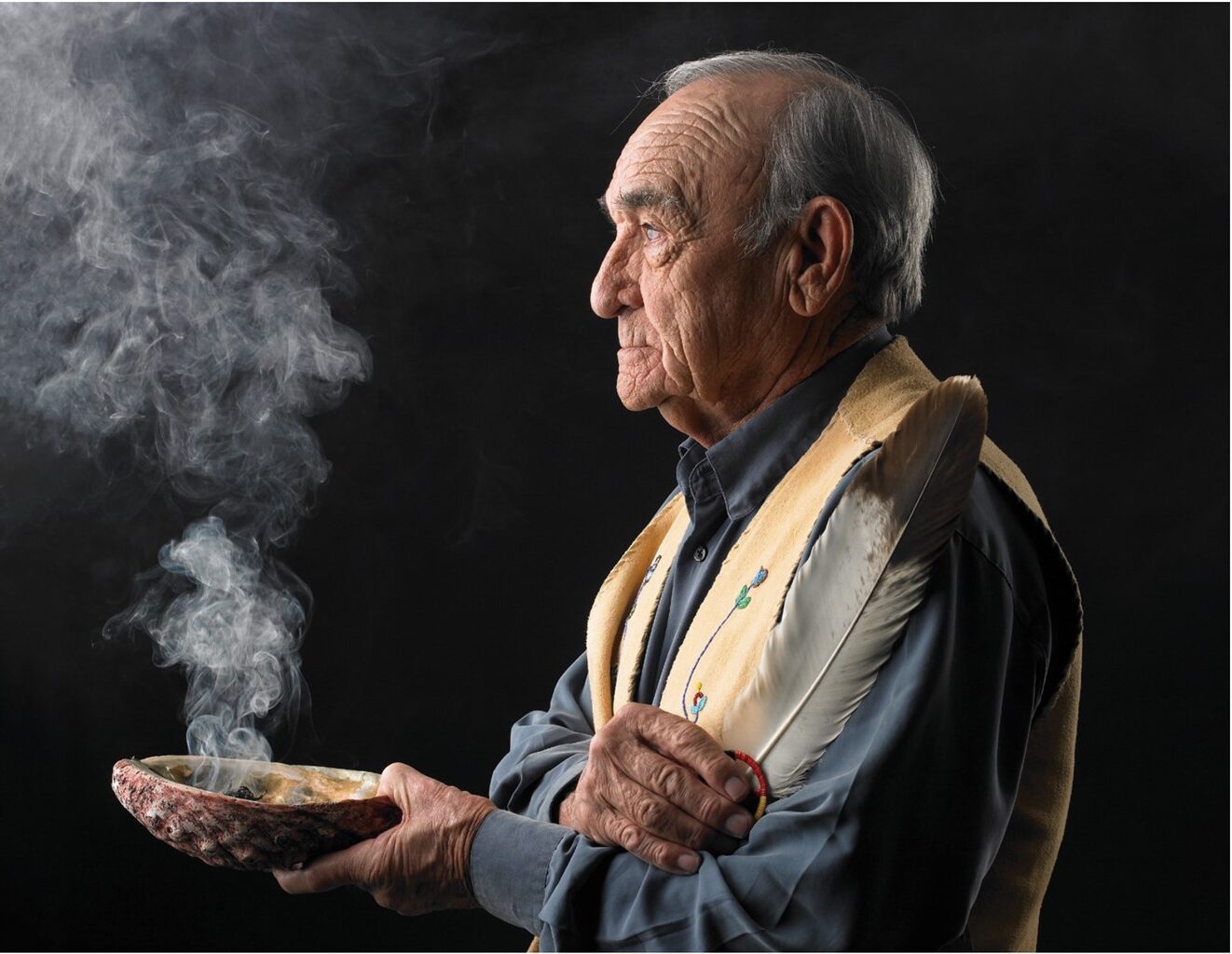 Homme âgé des Premières Nations tenant un bol de purification par la fumée et une plume.