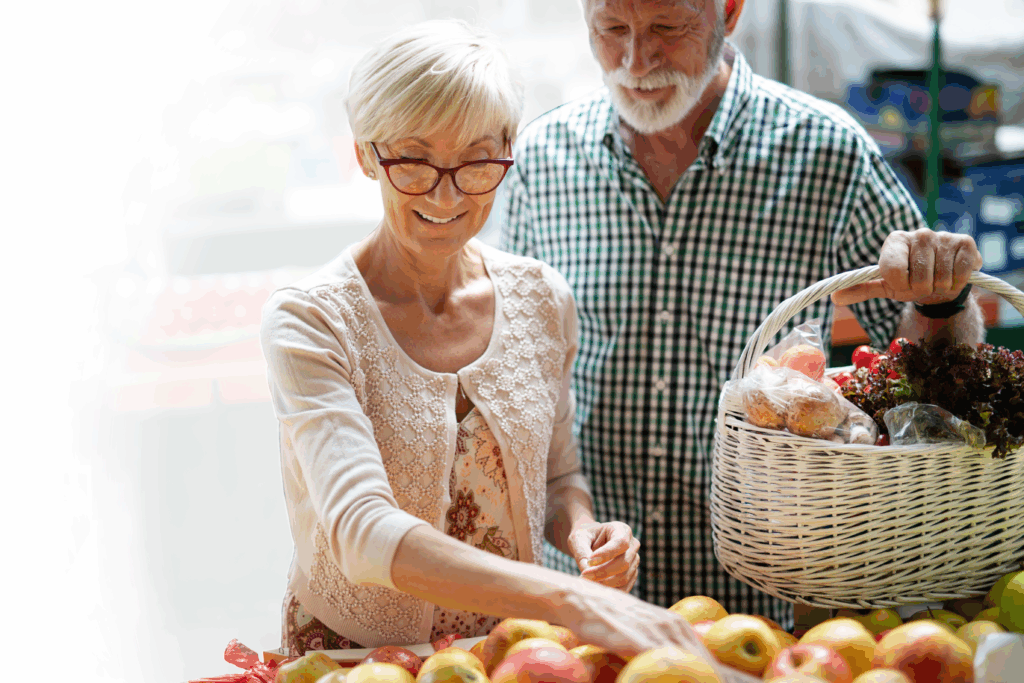Man and woman at a farmers market picking fruit