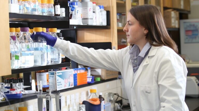 Young woman in research lab setting reviewing materials