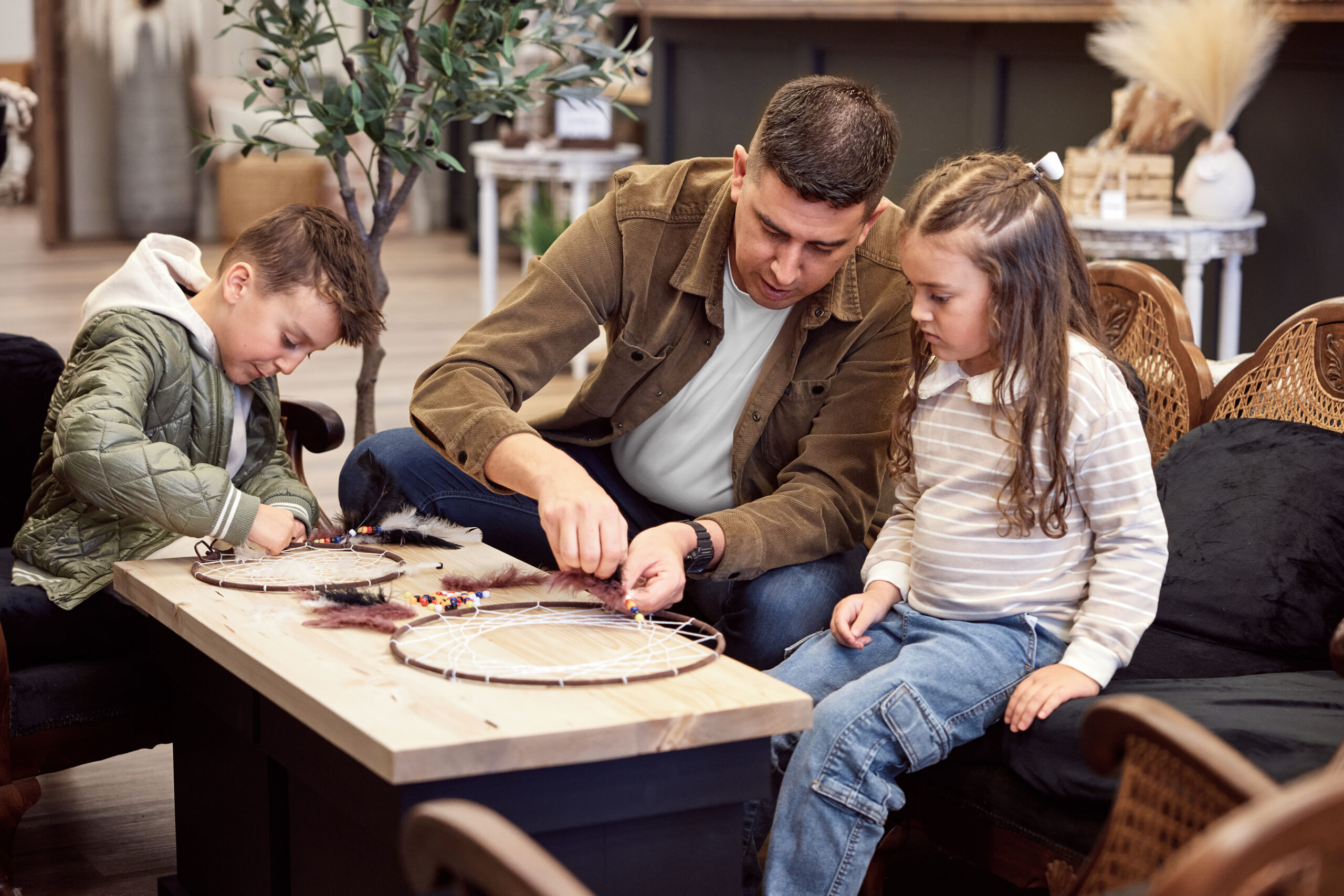 Un père et ses deux enfants, un fils et une fille, fabriquent des attrape-rêves