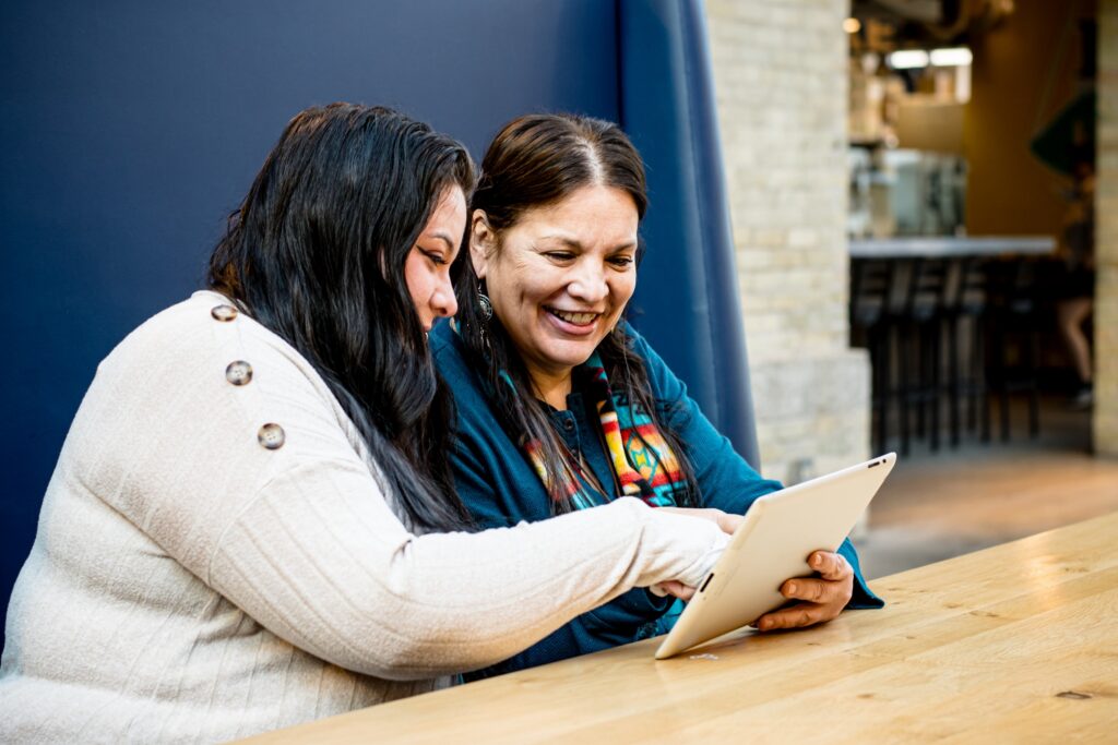 two Indigenous women using tablet